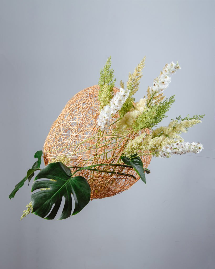 Объект из ротанга с заполнением дельфиниумом и монстерой. Работа студента Kazanflowerschool