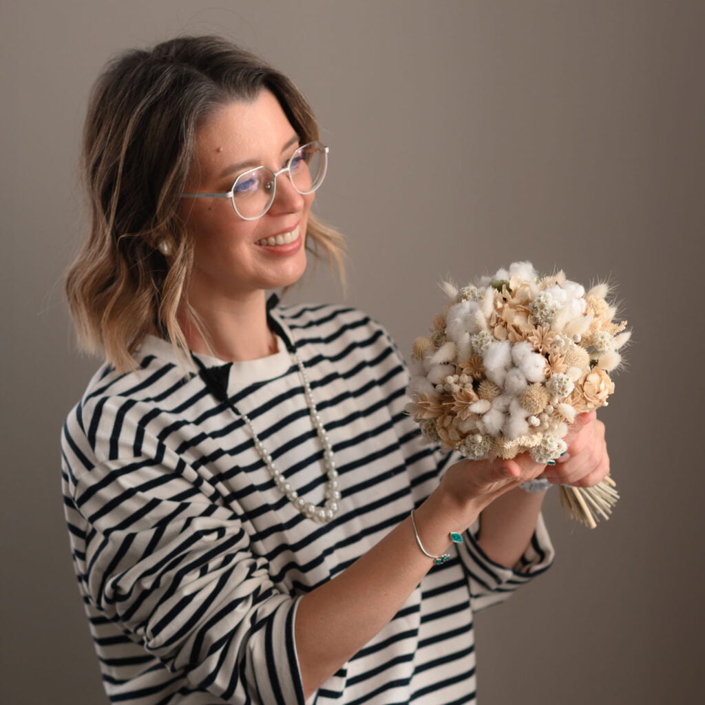 Женщина с букетом хлопка улыбается.